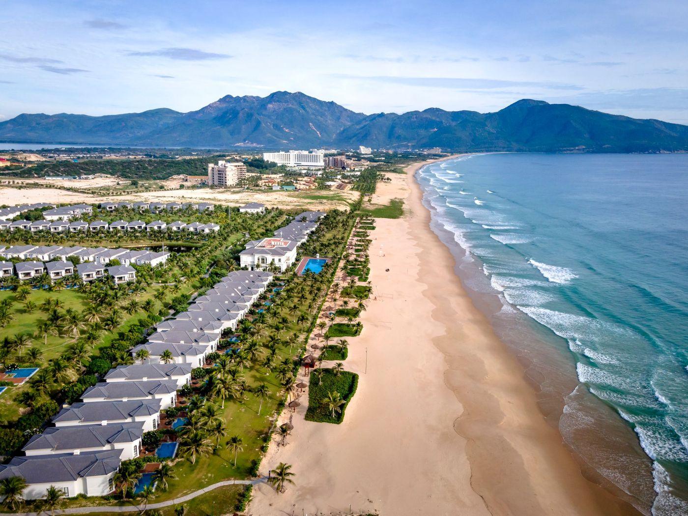 Beachfront resort buildings along a sandy shore with waves breaking