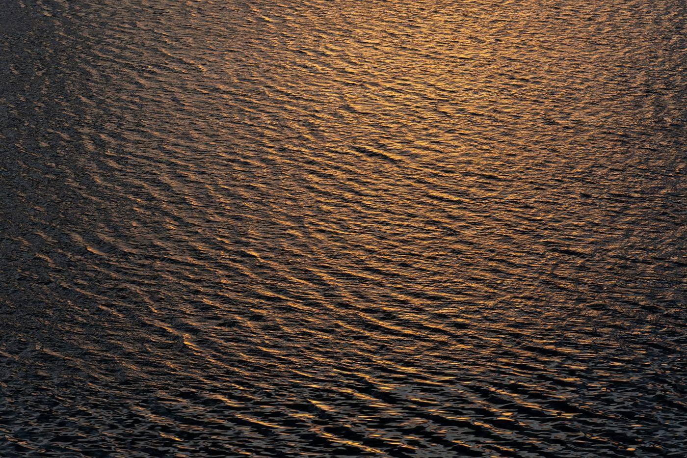 Golden light breaking across rippling open water